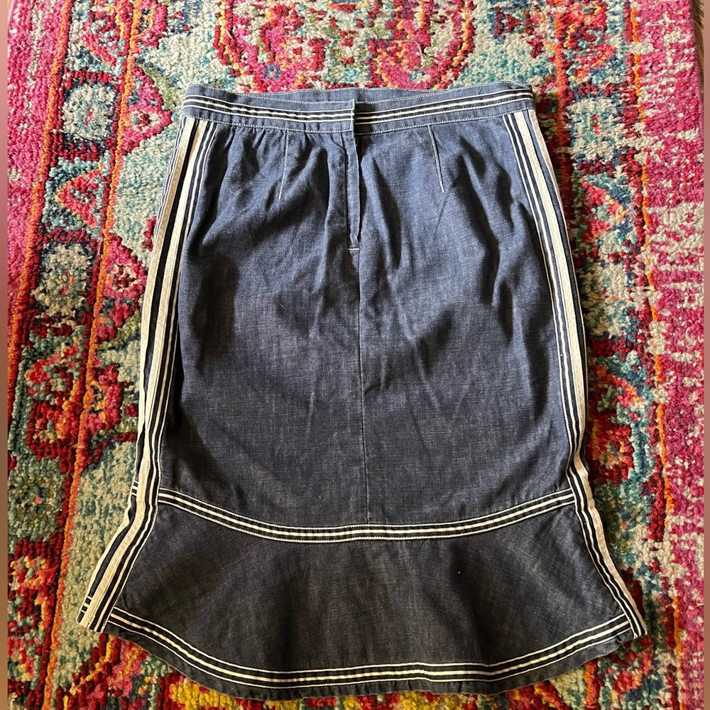Denim peplum style skirt with beige trim.